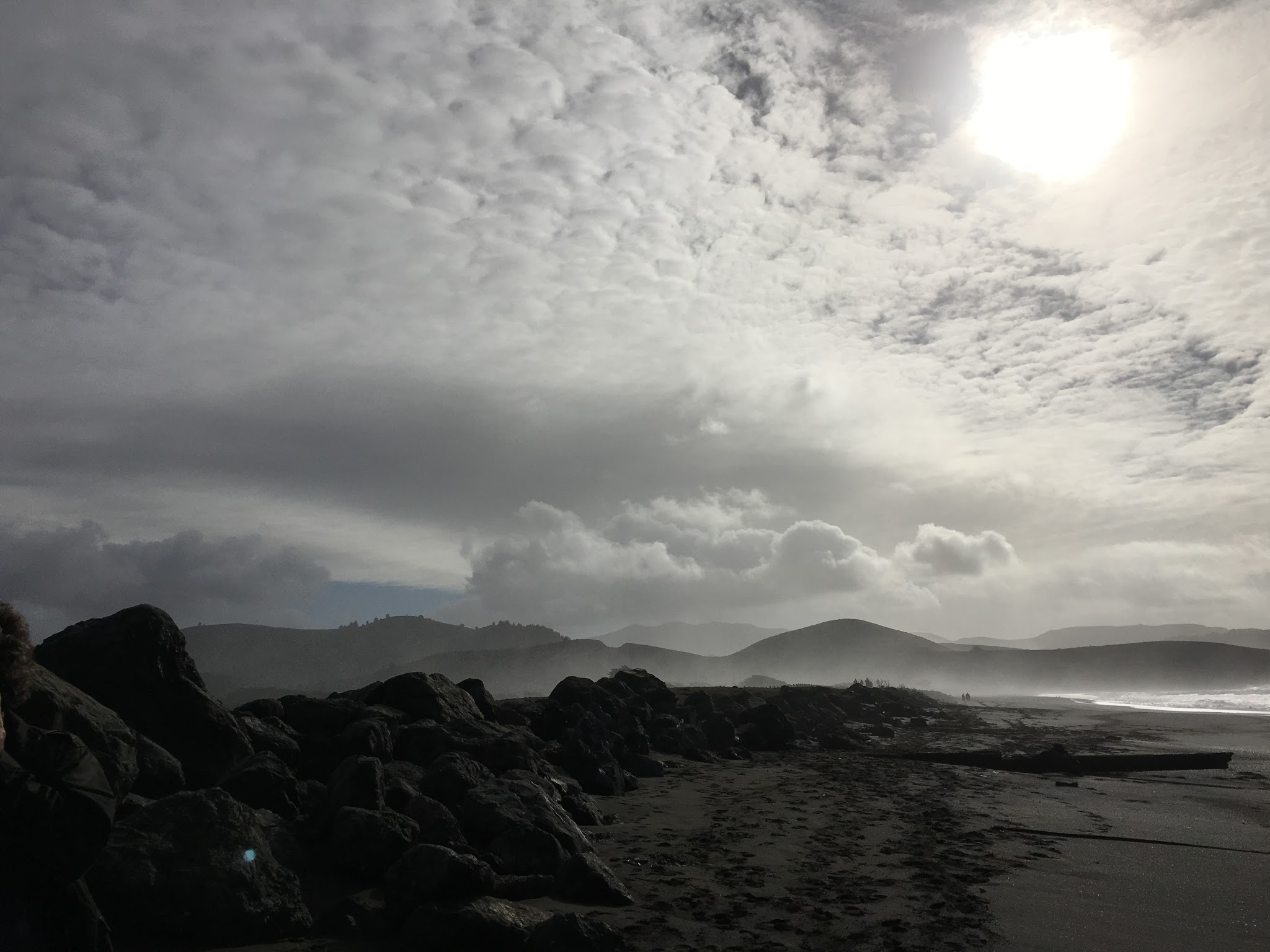 Gray, cloudy day at the gray sandy beach in Pacifica, California.